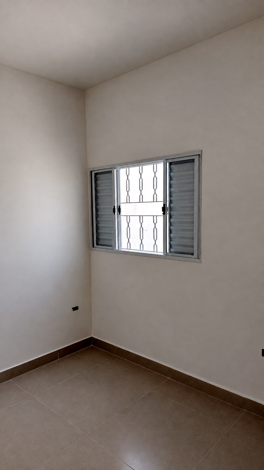 Quarto com janela e grade